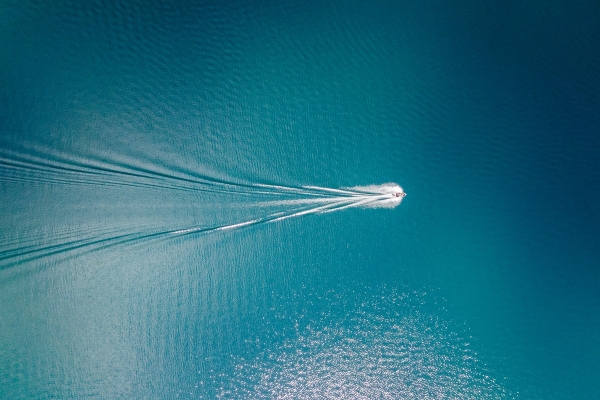 Speed Boat driving through Blue Green Ocean