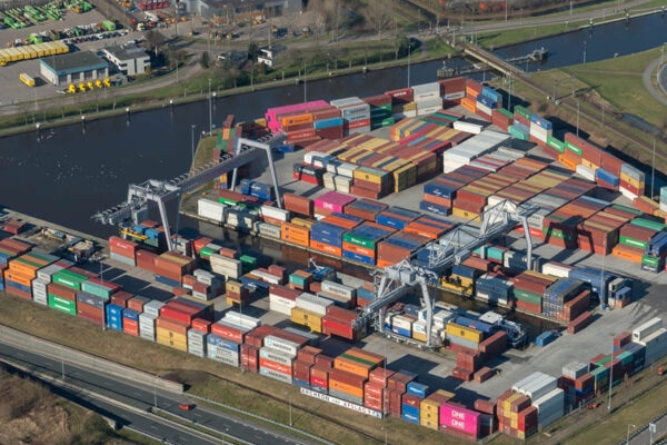 Ariel view of multi-coloured shipping containers beside a river