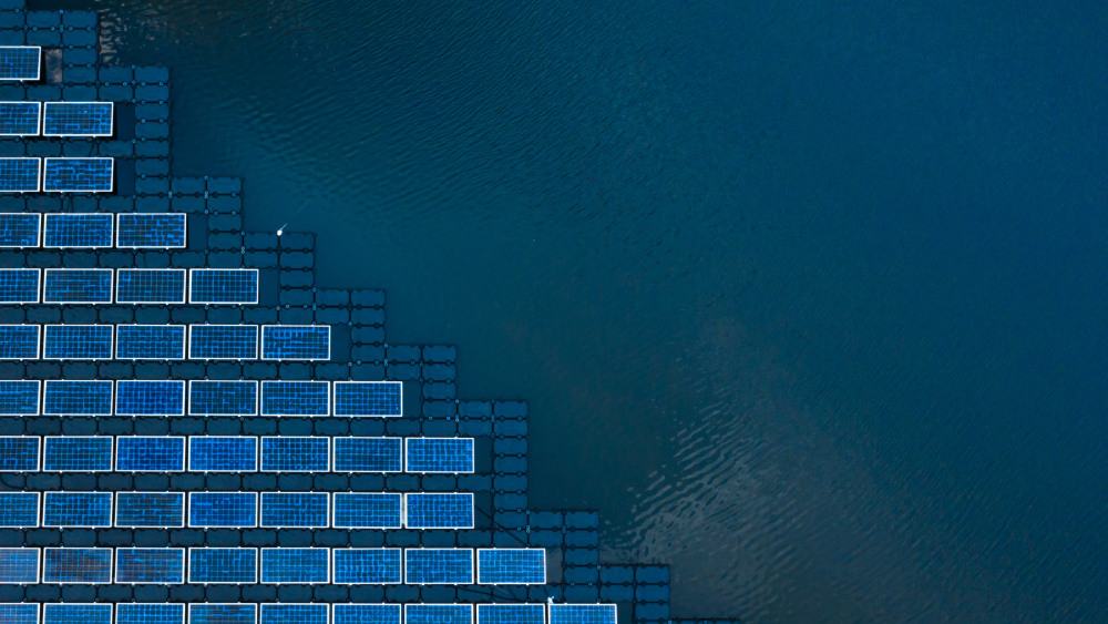 Solar panel tiles beside a large expanse of water