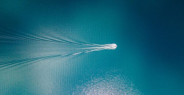 Speed boat driving through blue green ocean