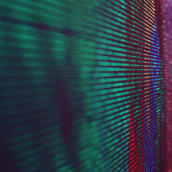 Green red pink and orange textured dots close up