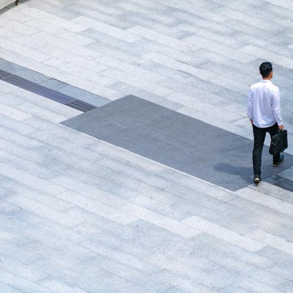 Business person walking through courtyard 